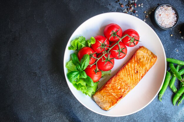 Salmón frito con ensalada verde en un plato