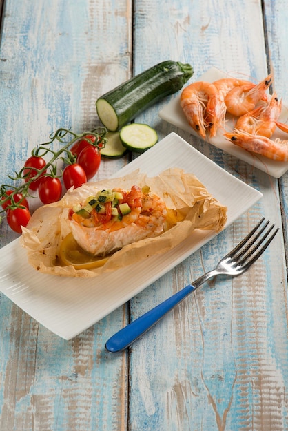 Foto salmón y gambas envueltos con tomates y calabacines