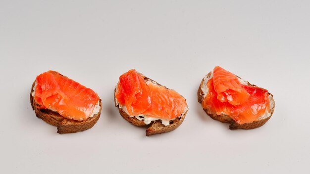 Salmón en un pan con crema aislado en blanco