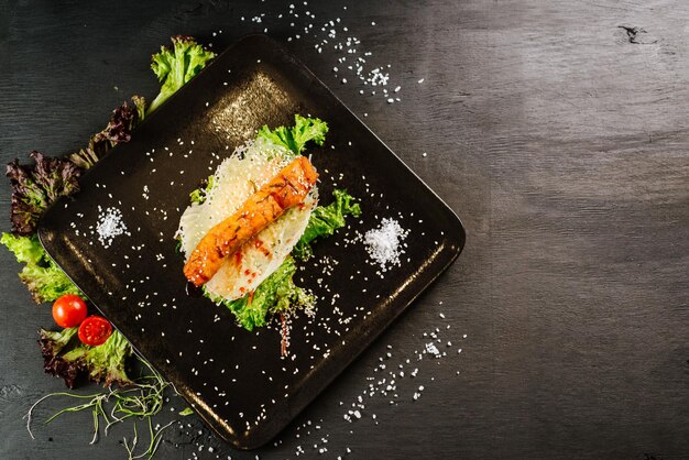 Salmón de pescado rojo a la parrilla sobre fondo negro