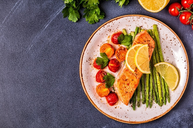 Salmón a la plancha con espárragos y tomates, vista superior.