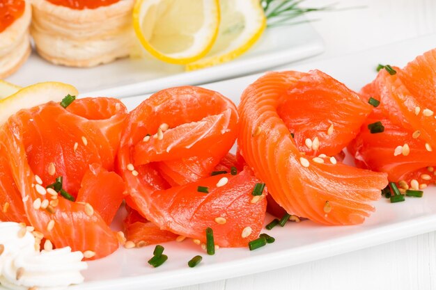 Salmón en rodajas con semillas de sésamo en un plato blanco