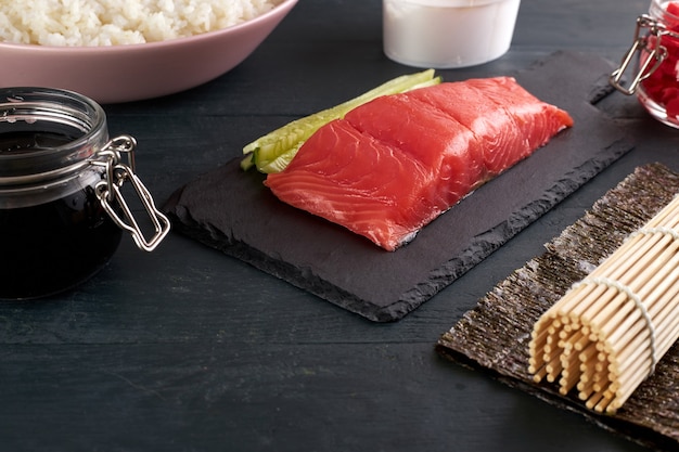 Salmón rosado en una tabla para servir de piedra con pepinos