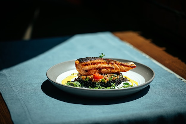 Salmón con salsa cremosa de albahaca y arroz negro