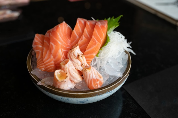 Salmón sashimi crudo en rodajas y salmón ahumado sobre hielo en un tazón en el restaurante japonés