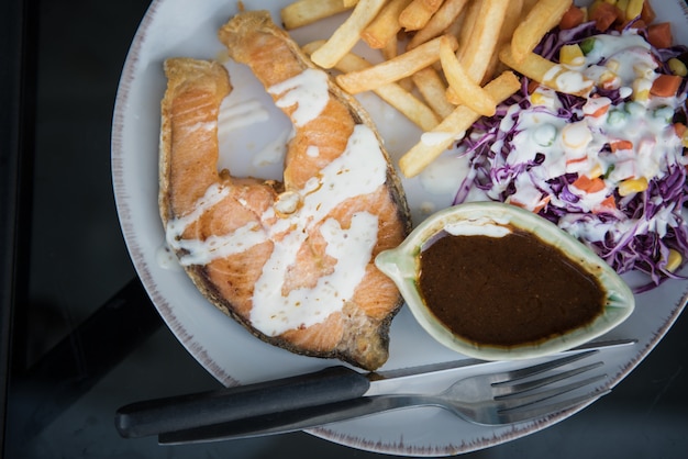 Salmones con colorido de las recetas de la ensalada en la placa blanca para la cena - concepto sano de la comida.