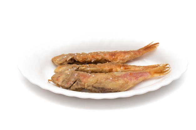 Salmonete frito, em um prato, isolado no fundo branco. Conceito de comida espanhola.