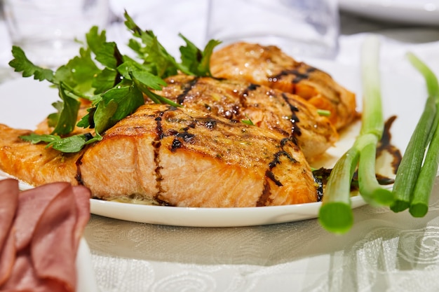 Salomón al horno con hierbas en un plato sobre una mesa servida