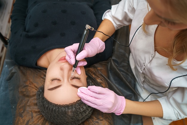 En el salón de belleza en el artista del tatuaje hermoso cliente feliz.