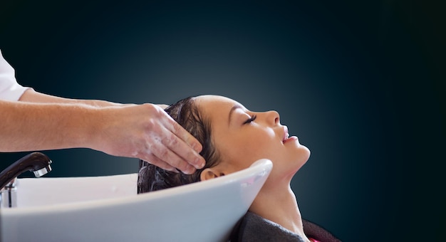 salón de belleza y concepto de personas - mujer joven feliz y manos de peluquero lavando la cabeza y el cabello sobre fondo negro en blanco