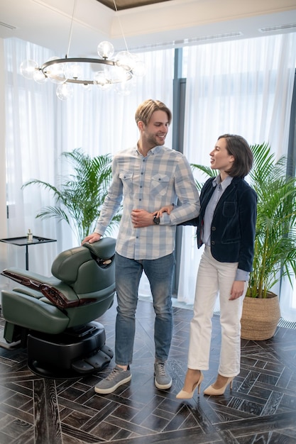 Salón de belleza. Un hombre alto y mimado con su peluquero en el salón de belleza.