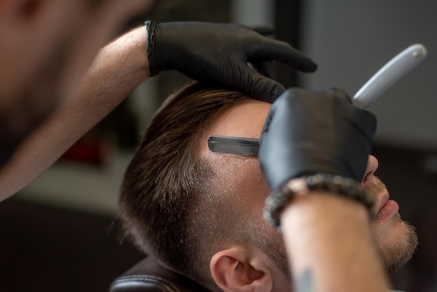 Foto salón brutal hombre sentado en una silla de peluquero