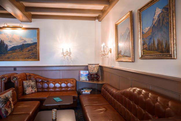 Salón clásico con tonos neutrales arte del paisaje de montaña y sofás de cuero