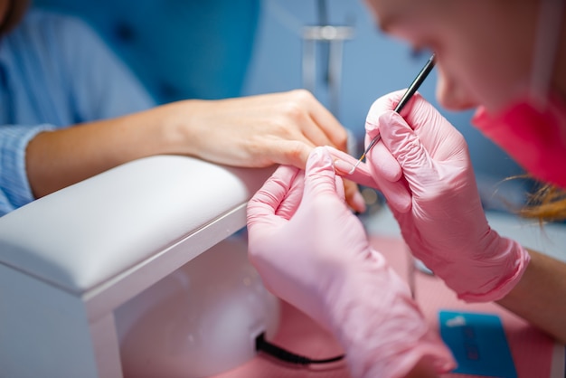 Salón de cosmetología, manicura, aplicación de barniz.