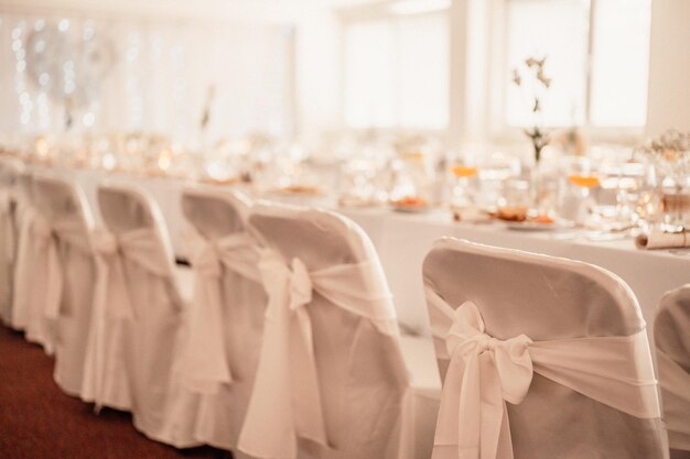 Salón decorado para la ceremonia de la boda Banquete de bodas Las sillas y la mesa redonda para los invitados se sirven con cubiertos de flores