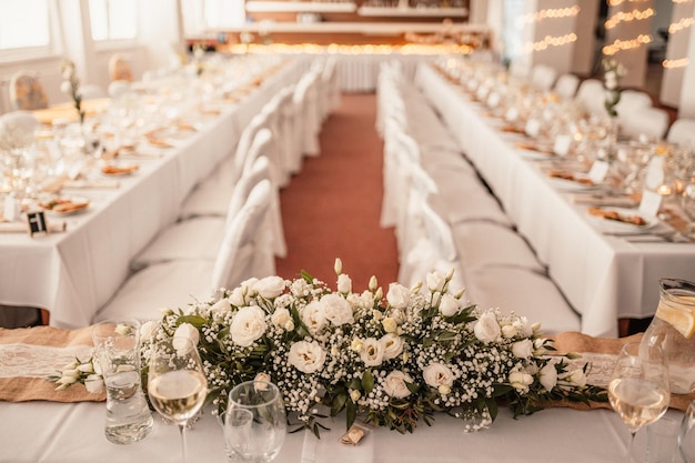 Salón decorado para la ceremonia de la boda Banquete de bodas Las sillas y la mesa redonda para los invitados se sirven con cubiertos de flores