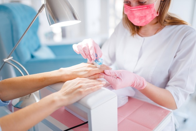 Salón de esteticista, manicura, procedimiento de esmalte de uñas.