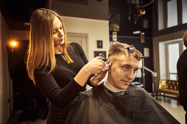 Salon Mann in einem Friseurstuhl Der Friseur bedient den Kunden im Friseursalon Das Konzept der männlichen Kosmetologie