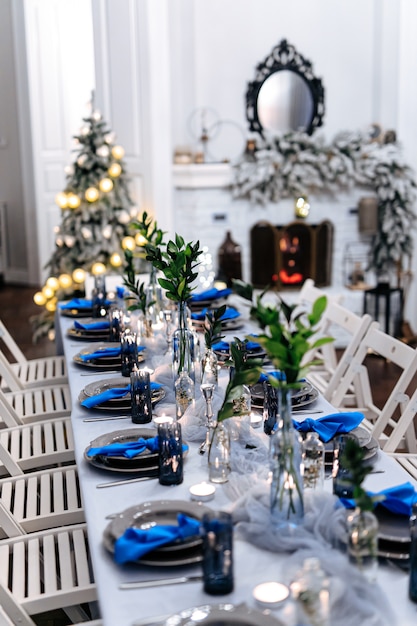 Salón con mesa servida, chimenea y árbol de navidad.
