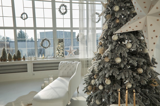 Salón navideño con un árbol de navidad y regalos debajo de él estilo clásico moderno Interior blanco brillante y limpio de lujo Una habitación espaciosa con luz solar