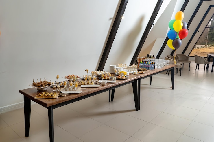 Foto salón restaurante hay una mesa con catering bocadillos hamburguesas camarones el salón con globos