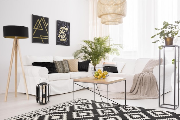 Un salón con un sofá blanco y una alfombra negra y dorada con una alfombra negra y blanca con una alfombra dorada y negra.