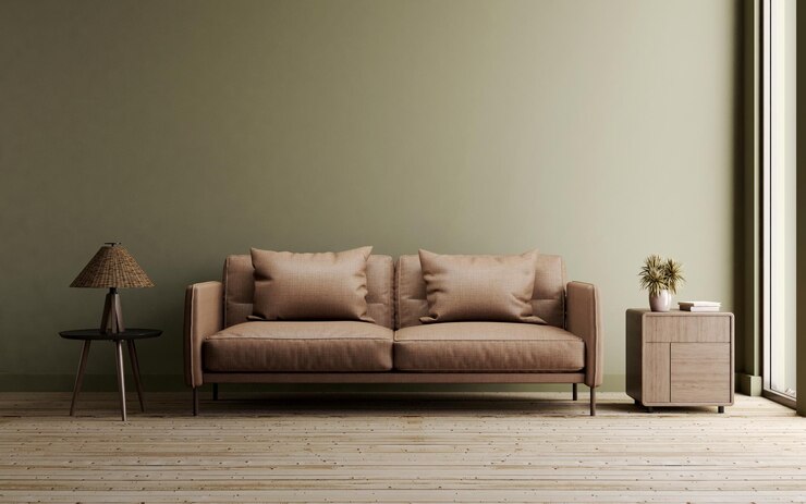 Salón con sofá marrón sobre suelo de madera y pared verde oscuro