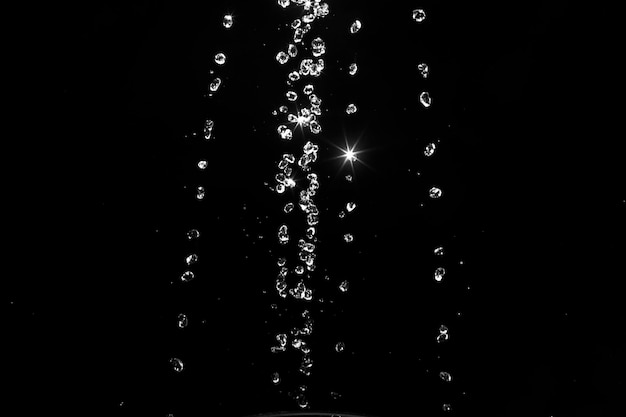 Salpicaduras de agua aisladas sobre fondo negro chorros blancos con gotas