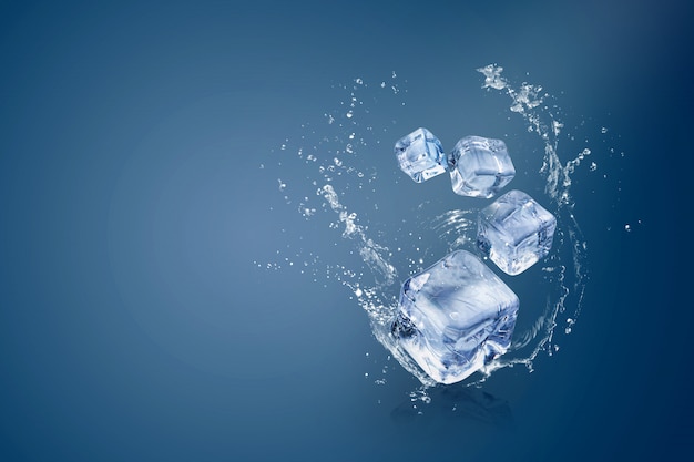 Salpicaduras de agua en cubitos de hielo aislados sobre un fondo azul y espacio de copia