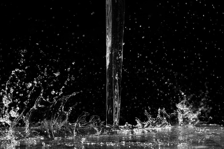 Salpicaduras de agua sobre fondo negro Chorro y gotas de líquido transparente Verter agua transparente