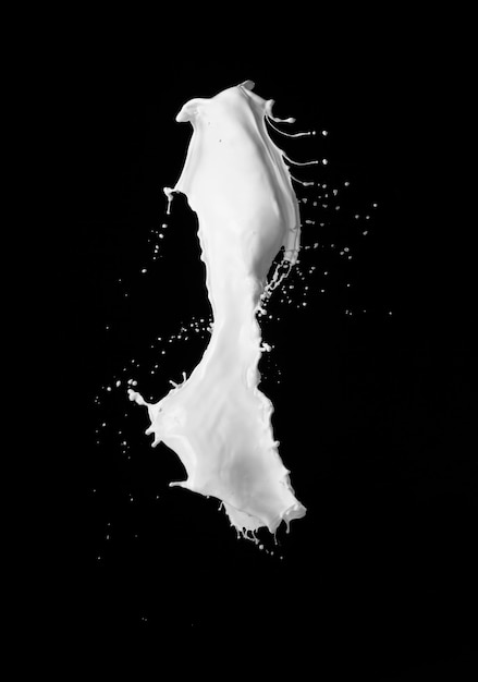 Foto salpicaduras de leche sobre fondo negro