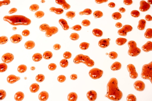 Salpicaduras de mermelada roja aislado sobre un fondo blanco.