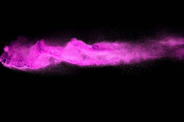 Foto salpicaduras de partículas de polvo rosa sobre fondo negrosalpicaduras de polvo rosa