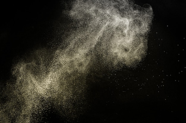 Foto salpicaduras de polvo dorado para maquillador o diseño gráfico en fondo negro