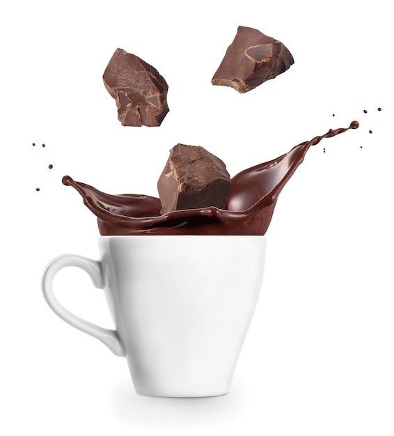 Foto salpicando chocolate caliente con pedazos que caen en la taza aislados sobre un fondo blanco
