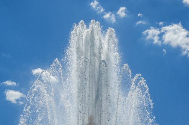 Salpicos da fonte contra o céu azul