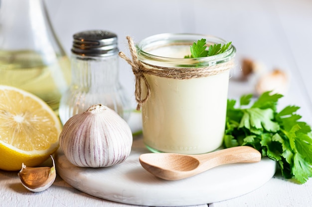 Salsa alioli en un enfoque selectivo de fondo blanco de madera