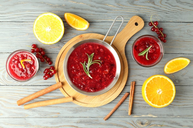 Salsa de arándanos e ingredientes en mesa de madera gris