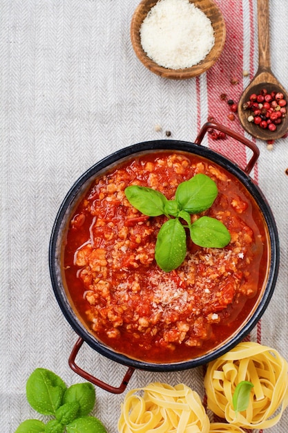 Salsa boloñesa italiana tradicional en saucepot un viejo fondo de madera oscura Espacio de copia de vista superior