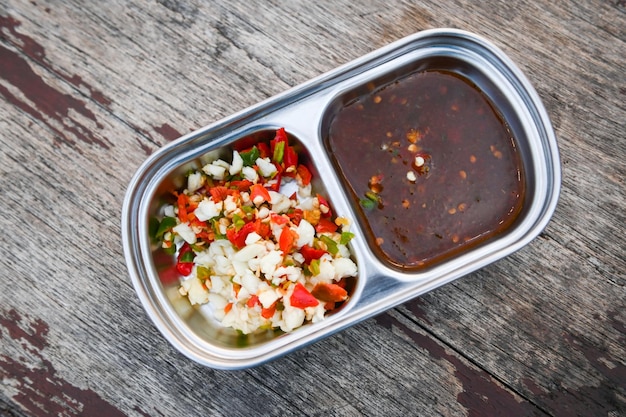 Salsa de chile con ajo deliciosa salsa para mojar con ajo en una taza sobre fondo de comida de mesa de madera