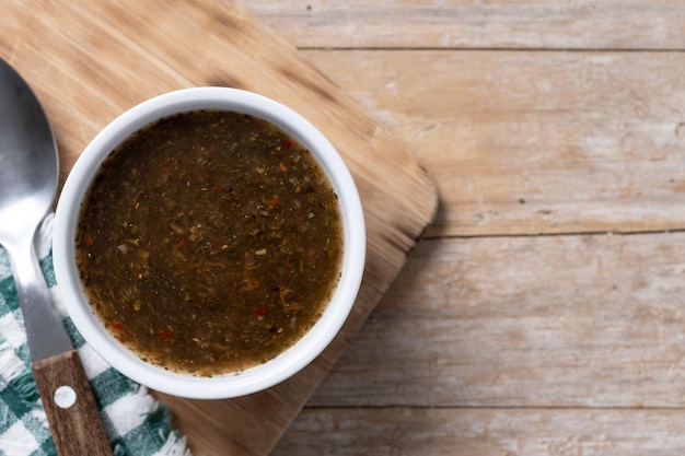 Salsa de chimichurri verde en una mesa de madera