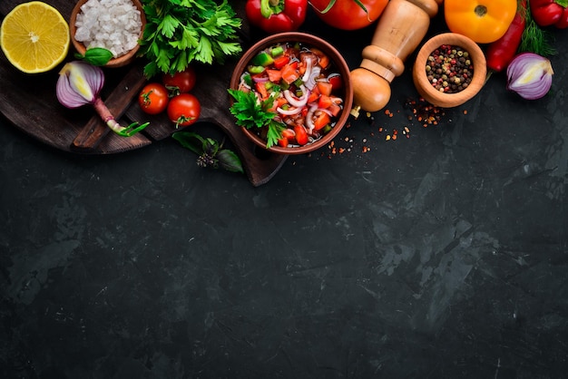 Salsa e ingredientes Salsa tradicional mexicana latinoamericana Vista superior Sobre fondo negro Espacio libre para texto