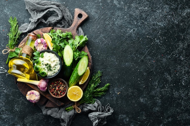 Salsa griega tradicional Pepino mantequilla de limón y ajo sobre fondo culinario antiguo Vista superior Espacio libre para el texto