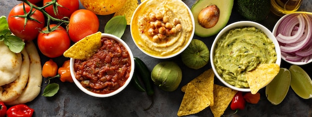 Foto salsa de hummus casera y guacamole con papas fritas de maíz