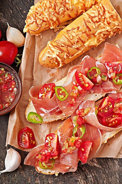 Salsa de inmersión en un tazón de palitos de pan y queso sobre fondo de madera
