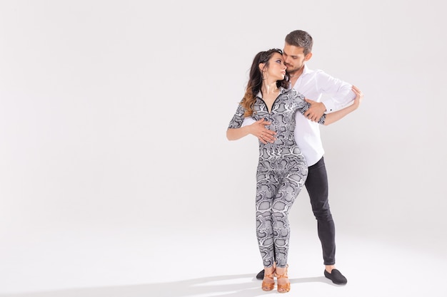 Salsa-, Kizomba-, Tango- und Bachata-Tänzer auf weißem Hintergrund mit Kopienraum. Gesellschaftstanzkonzept