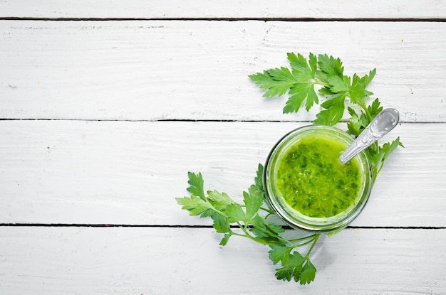 Salsa de perejil verde Ingredientes para salsa chimichurri Sobre un fondo blanco de madera Vista superior espacio libre para el texto