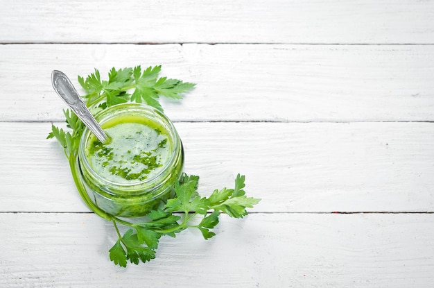 Salsa de perejil verde Ingredientes para salsa chimichurri Sobre un fondo blanco de madera Vista superior espacio libre para el texto