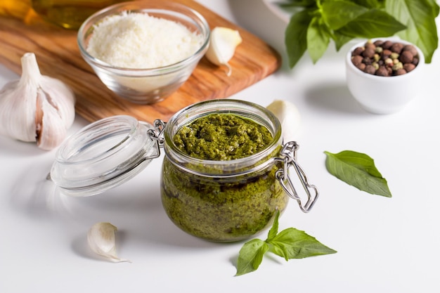 Salsa de pesto de albahaca en un frasco Ingredientes para cocinar queso parmesano ajo aceite de oliva