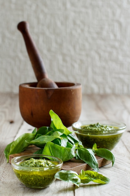 Salsa pesto y albahaca fresca sobre una mesa de madera